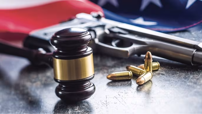 Gavel, handgun and ammunition on a table