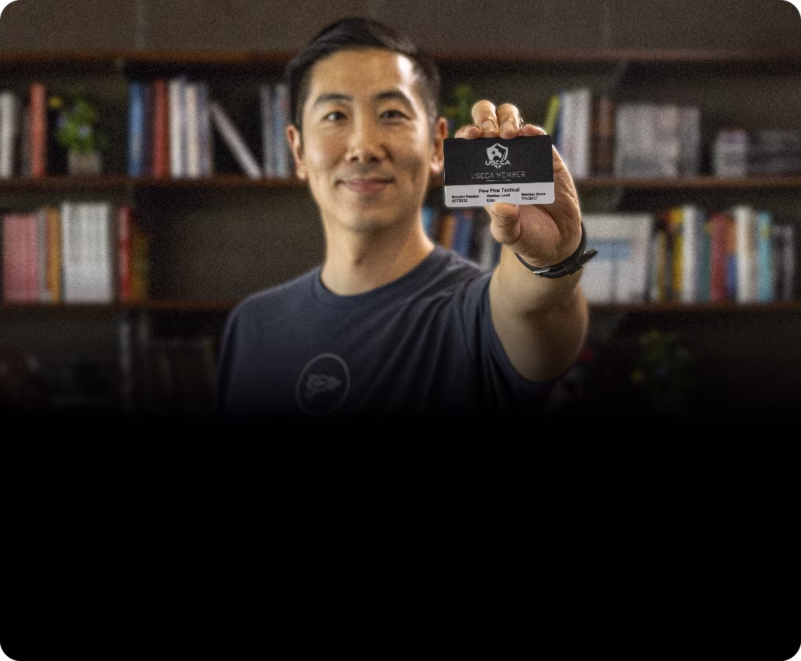 A man proudly showing his USCCA membership card