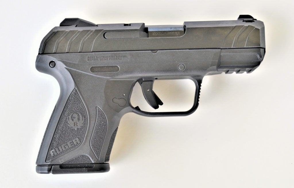 A Ruger Security-9 compact 9mm concealed carry pistol facing with the barrel to the right over a white background