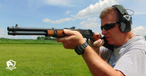 A man wearing ear and eye protection test fires the Rossi R92 Carbine Rifle.
