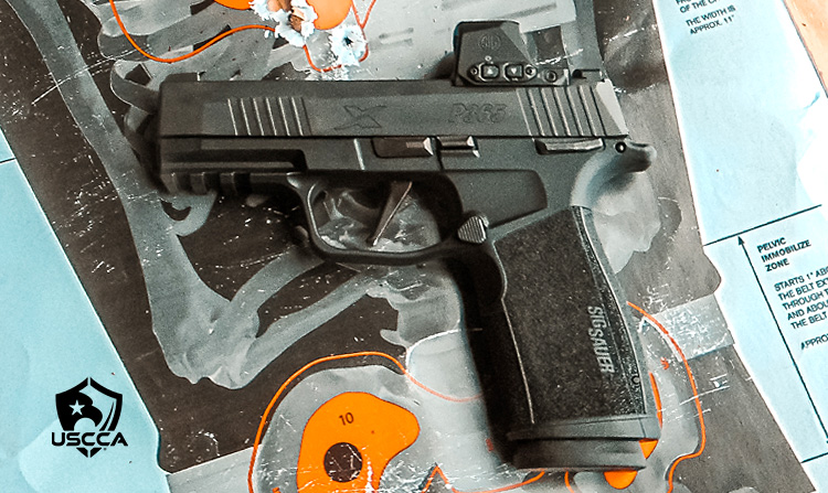 The SIG-Sauer P365-XMacro atop a target with a tight group of shots.