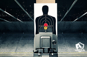 A silhouette target at an indoor shooting range viewed through handgun sights.