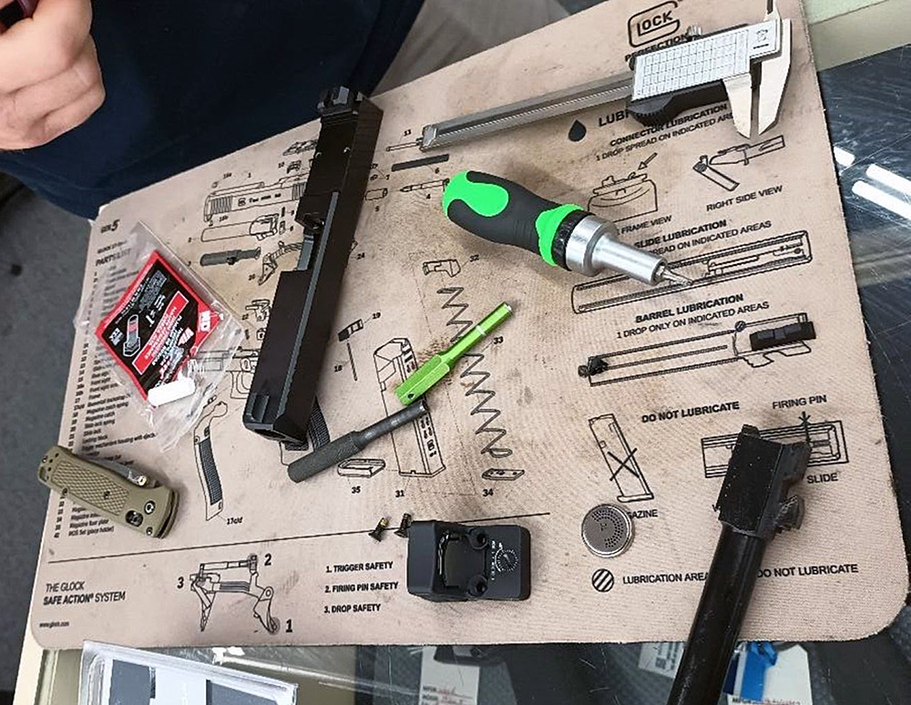 All the tools needed to mount an optic on top of a gunsmith mat.